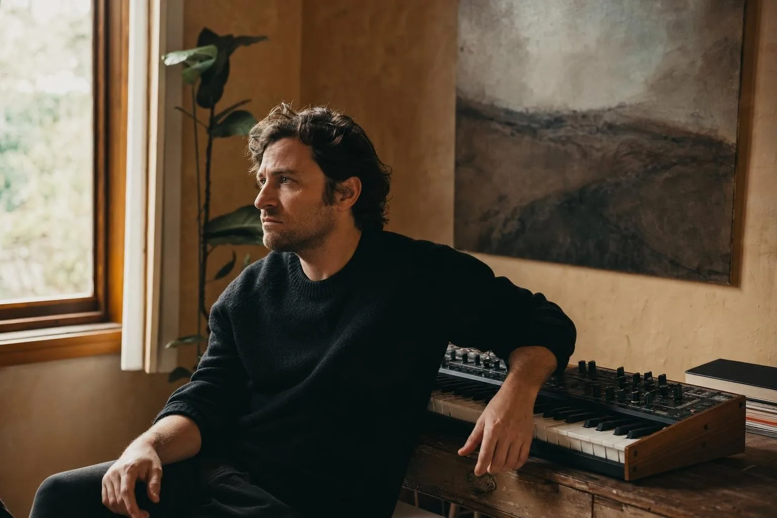An artist writing at a piano in a warm room